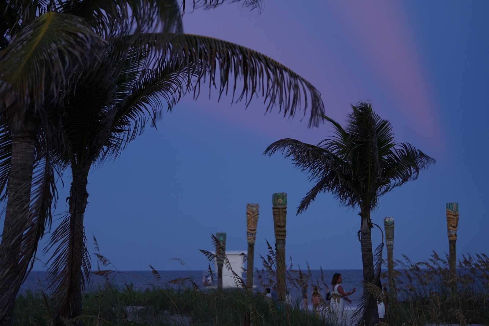 Palms and tiki carvings at dusk on Cocoa Beach